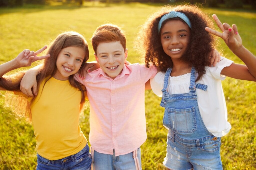 Three young kids posing and smiling