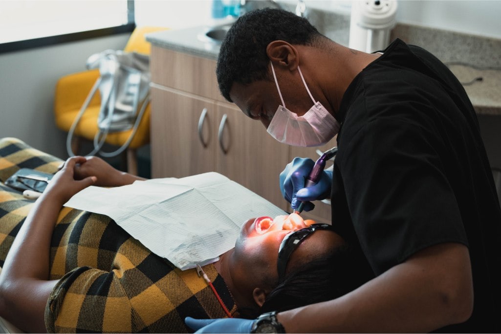 Team member examining patient's teeth